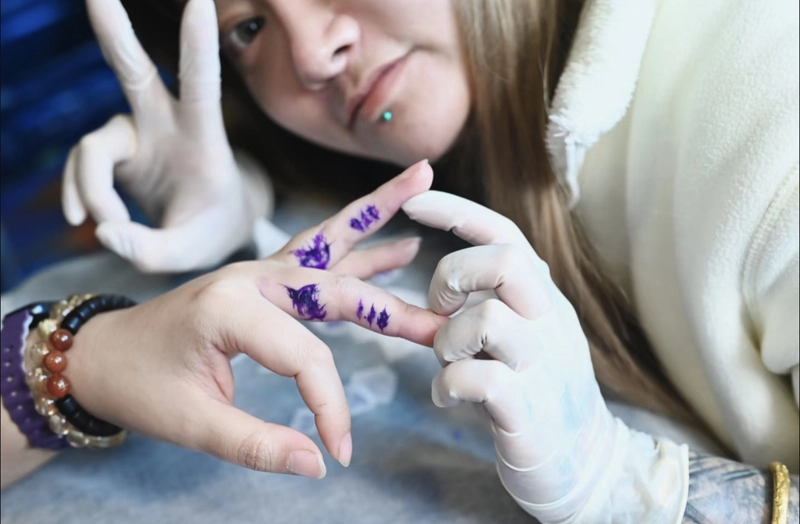 Hình xăm chữ cái ở ngón tay nữ