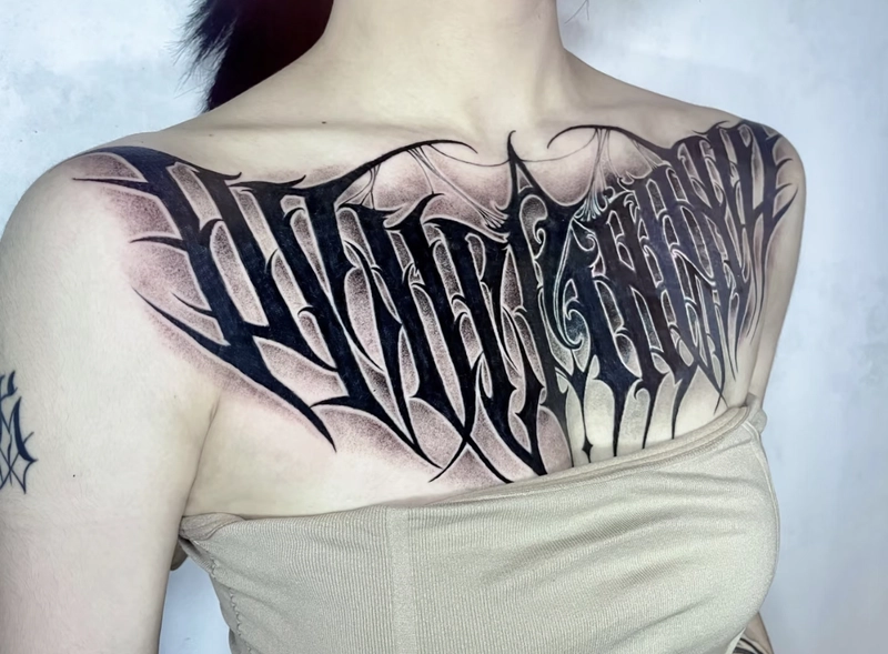 Hình xăm mini chữ ở ngực nữ