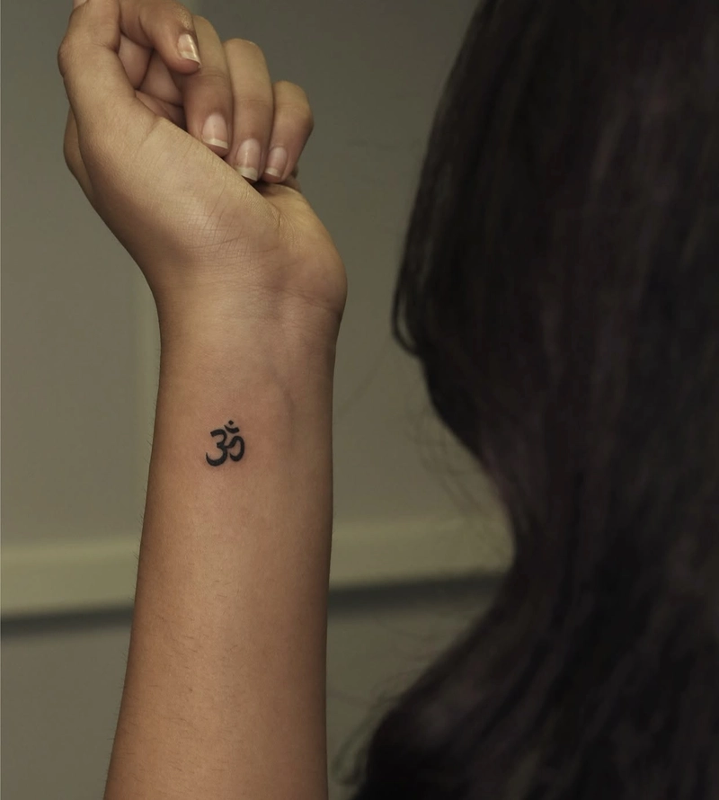 hình xăm chữ Om tượng trưng cho sự thiêng liêng của vũ trụ
